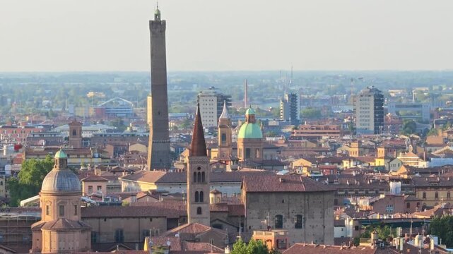 Close up of the tower on the cityscape of Bologna in Italy. The medieval Two Towers are the symbol of city in the blue sky. Asinelli and Garisenda tower in historic downtown with the town buildings.