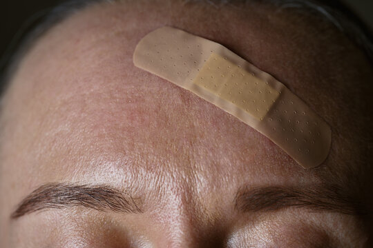 Close-up of forehead with bandage for minor injury care
