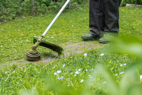 Grass trimming in a backyard with workwear in spring