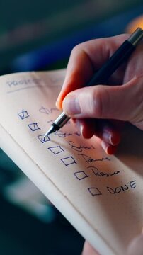 Checklist Ticking Task Notebook Project Achievement Success Hand Holding Pen Close Up view business person completing goals on list
