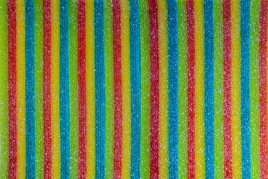 Rainbow sour candy strips with granulated sugar texture pattern