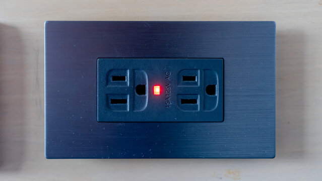 Electric power outlet with glowing indicator light