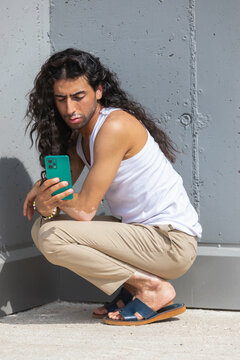 Middle Eastern man with vitiligo checking smartphone outdoors