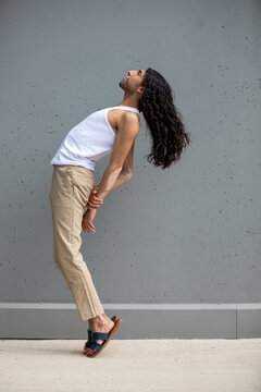 Middle Eastern man with vitiligo stretching in urban wall
