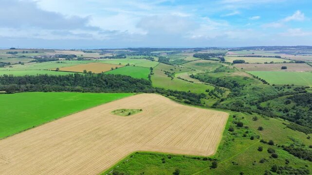 Aerial shot travelling over the Somerset countryside and farmland on a summer day.