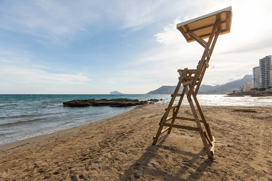Empty beach with lifeguard tower and distant skyline