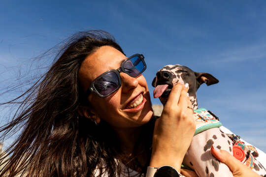 Smiling woman cuddling playful  outdoors in sunshine