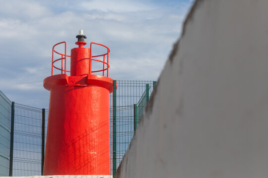 Red harbor beacon light on breakwater in Calpe, Spain