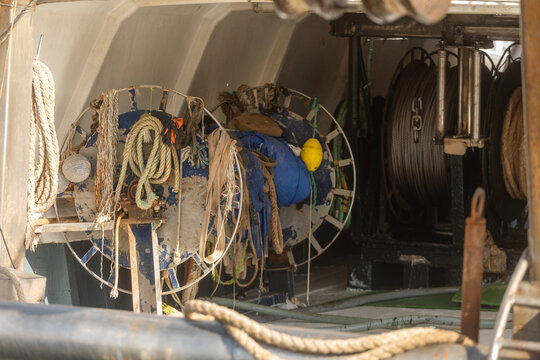 Fishing boat deck with rope reels, nets and working gear