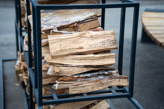 Stacked firewood on a metal rack for renewable energy