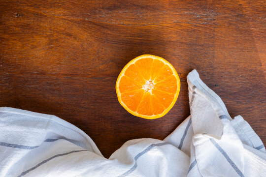 Half orange on wooden table with white cloth