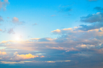 Obraz premium Blue sky background - sunset colorful clouds lit by sunlight