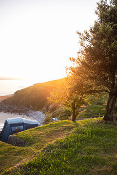 Sunset camping above coastal cliff with sea view