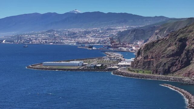 Scenic aerial footage of Santa Cruz de Tenerife harbor and Atlantic coastline with Mount Teide, Spain
