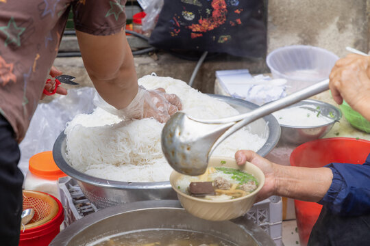 Street vendor preparing Vietnamese Pho Bo in Hanoi