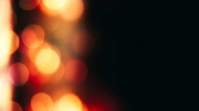 Abstract blurred background of warm golden and red bokeh lights against a dark backdrop
