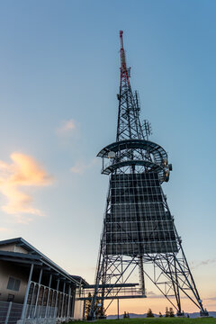 Radio communication tower with antenna and sunset sky
