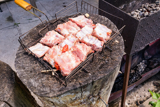 Raw pork ribs on grill over charcoal for summer barbecue