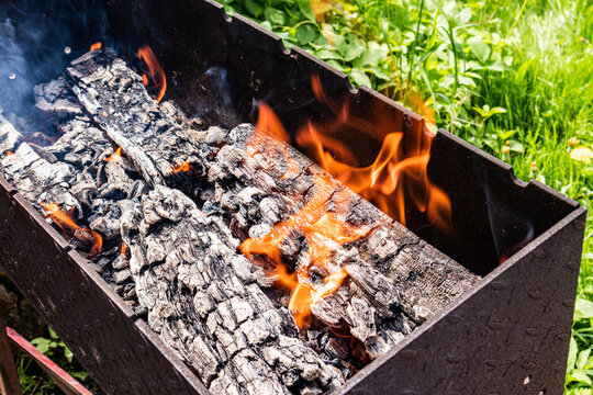 Outdoor charcoal barbecue fire burning in metal grill