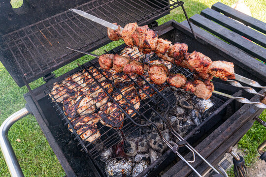 Summer barbecue grill with skewered meat over hot coals