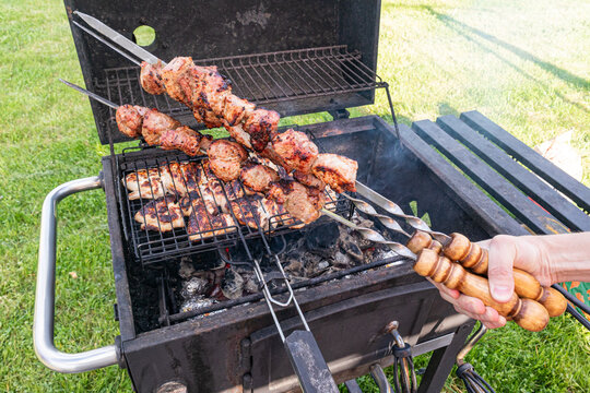 Grilled meat skewers cooking on outdoor barbecue grill