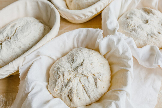 Rustic artisan bread dough fermenting in linen baskets