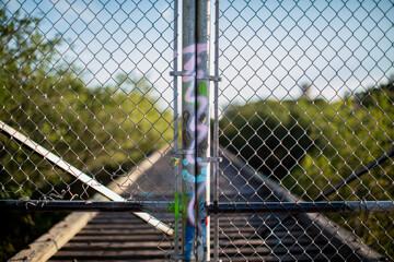 Fototapeta premium chain link fence with graffiti