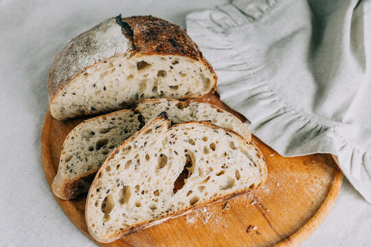 Rustic artisan bread slices on wooden board, organic