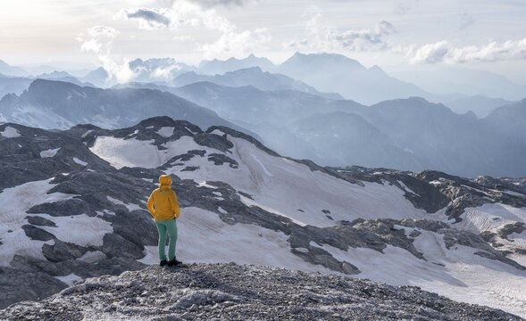 High alpine landscape, snowfields and rock, hiker Looking down into the valley from the Hochk&ouml;nig, Salzburger Land, Austria
