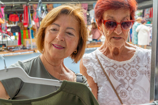 Senior women shopping outdoors at market in retirement