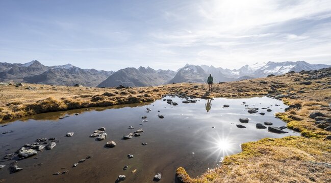 Mountaineers at a small lake on the high plateau of the Gurgler Seenplatte, glaciated mountain peaks in the background, in autumn, Sonnenstern, near Obergurgl, &Ouml;tztal Alps, Tyrol, Austria