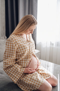 Pregnant woman relaxing on sofa, home comfort and health