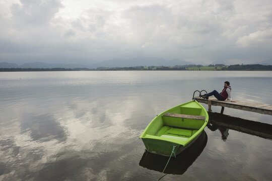 Woman 50-55, wooden jetty, green rowing boat, Hopfensee, Hopfen am See, near F&uuml;ssen, Ostallg&auml;u, Allg&auml;u, Bavaria, Germany