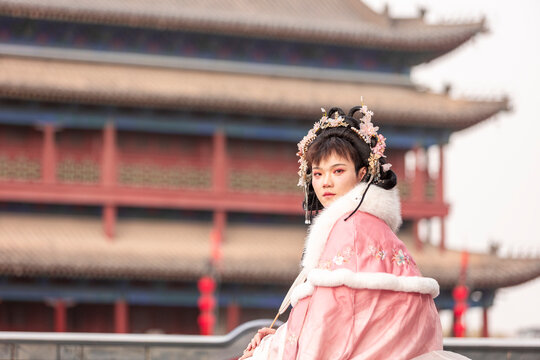 Man in hanfu at Xi'an city wall with ancient tower backdrop