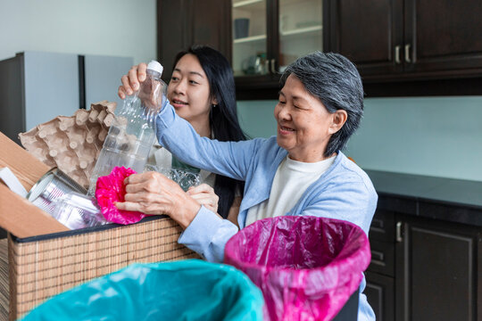 Asian family sorting household recycling in kitchen together