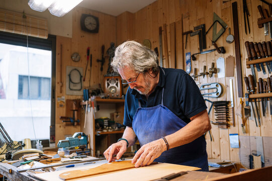 Man crafting guitar in workshop with passion and skill