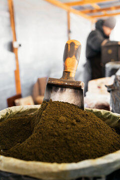 Loose domestic tobacco in sack with scoop at market stall