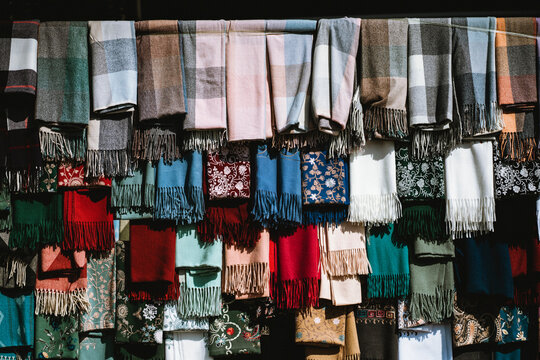 Assorted wool scarves with fringe hanging in market