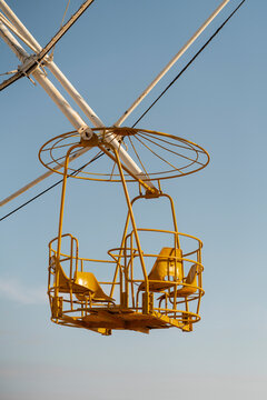 Yellow observation wheel cabin close-up against blue sky