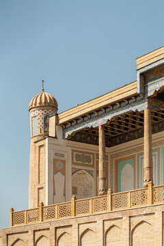 Ancient Bukhara madrasa facade with minaret and tiles