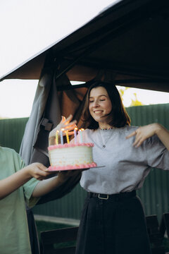 Young woman celebrating birthday with cake and candles