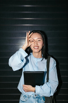Cheerful Asian businesswoman holding a folder
