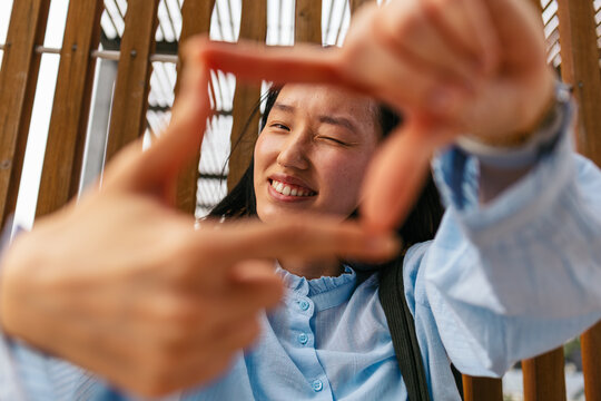 Businesswoman smiling while framing with hands