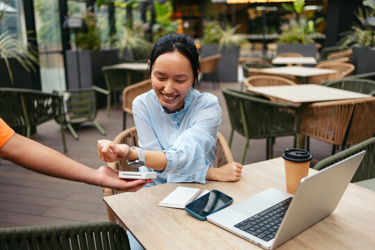 Businesswoman using smartwatch for payment outdoors