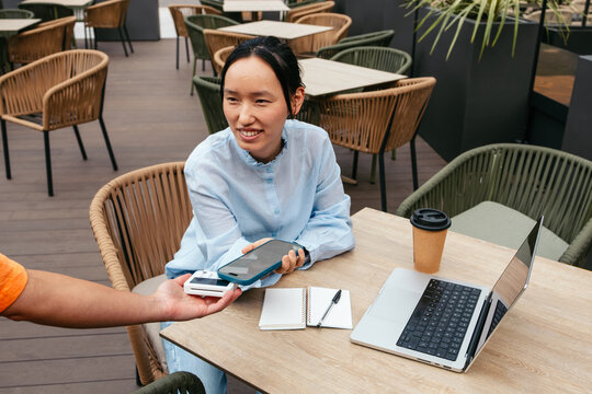 Asian businesswoman enjoying coffee in outdoor cafe