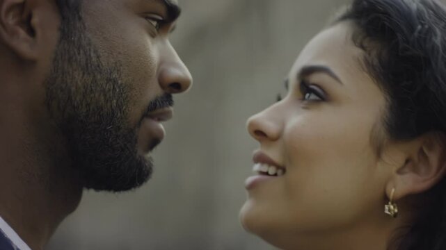 African American man and Hispanic woman share an intimate moment, their foreheads touching, with soft expressions and blurred background enhancing the emotional connection