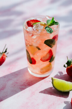 Refreshing strawberry mojito cocktail with lime and mint