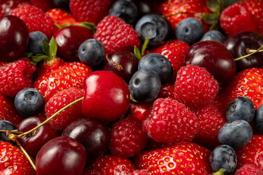 Fresh berry mix background with strawberries and cherry