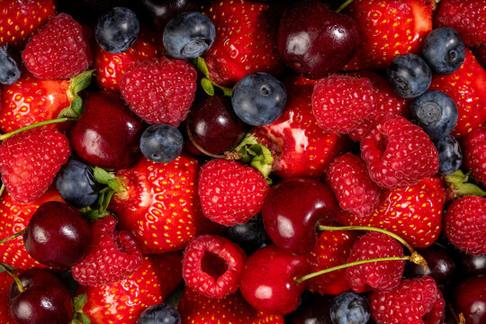 Fresh berry mix background with strawberries and cherries