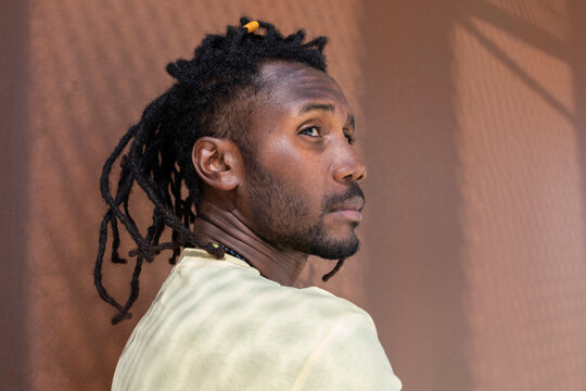 Cuban man in profile with dreadlock hairstyle outdoors